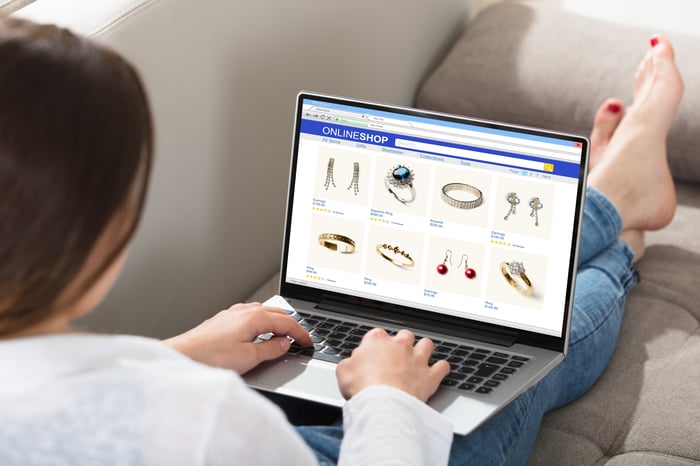 A person sitting with a laptop and shopping on an e-commerce site.