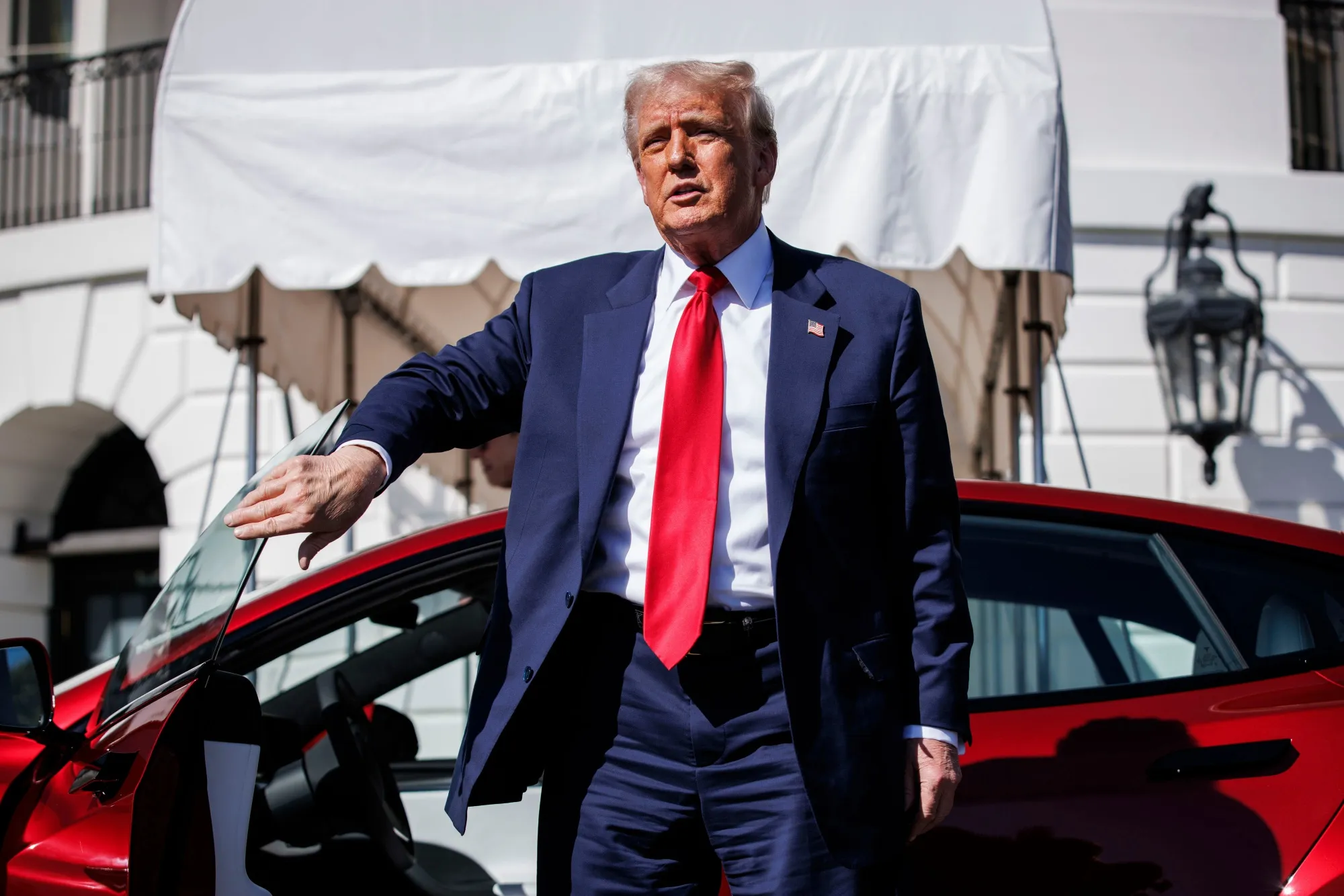 President Donald Trump exits a Tesla at a White House event in March.