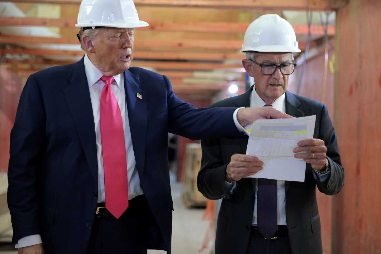 Donald Trump and Jerome Powell reviewing documents at a construction site.