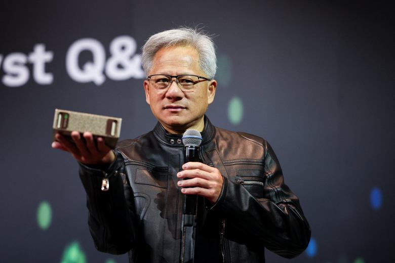 Jensen Huang, CEO of Nvidia, holds up a small object at a news conference.