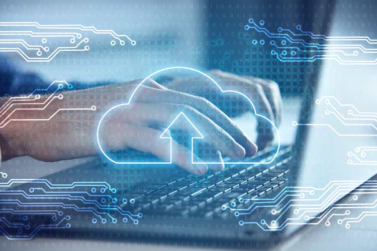 Businessman hands using laptop and cloud computing interface.