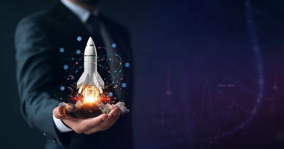 A person holding a tiny rocket.
