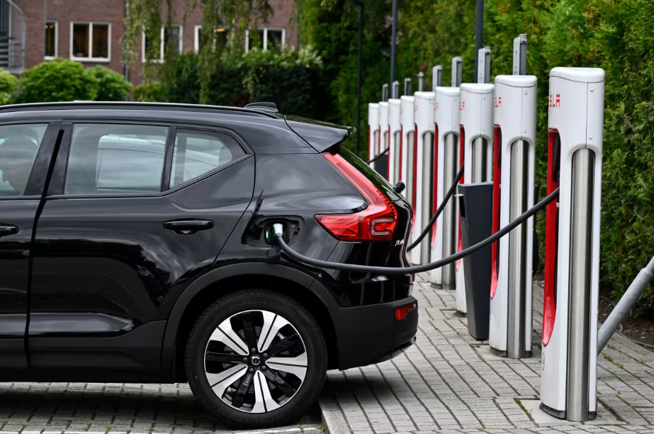 An electric car charges at a Tesla charger. The EV giant has opened up its network of chargers to other models in recent months.
